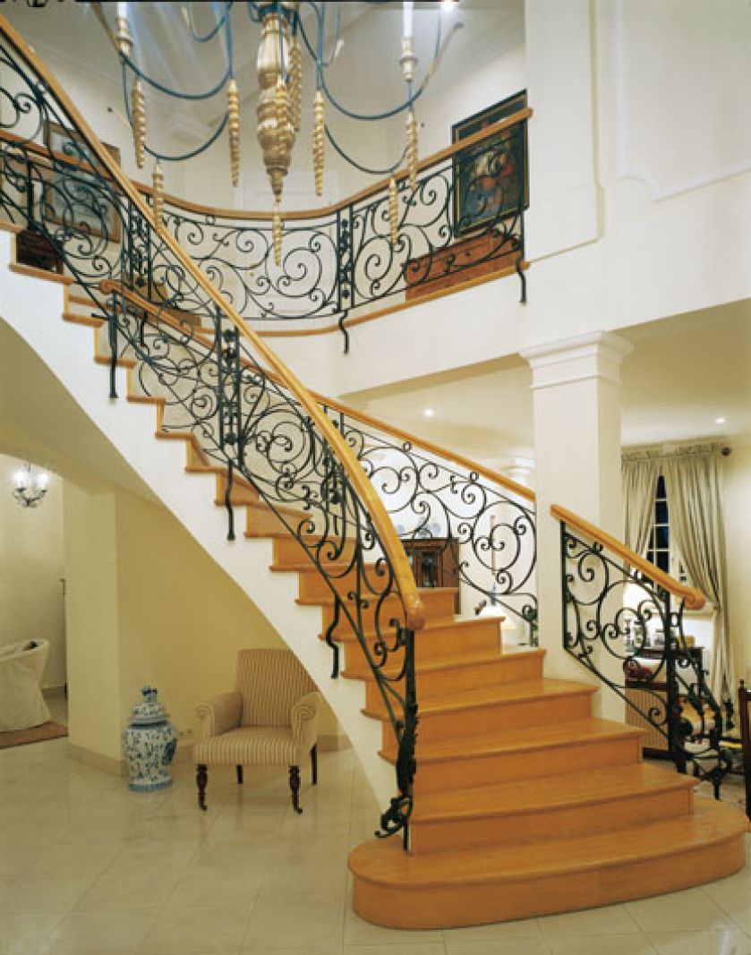 Już od wejścia dom otwiera się jasną przestrzenią holu wysokiego na dwa piętra, z imponującymi, miękko pnącymi się schodami.