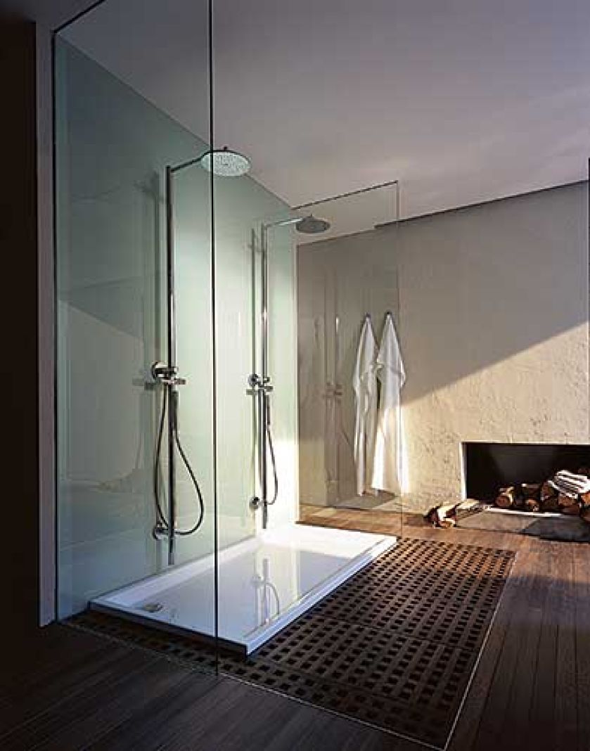 Chłodne szkło i beton skontrastowano z ciepłym drewnem na podłodze. Panel prysznicowy zaprojektował Philippe Starck.