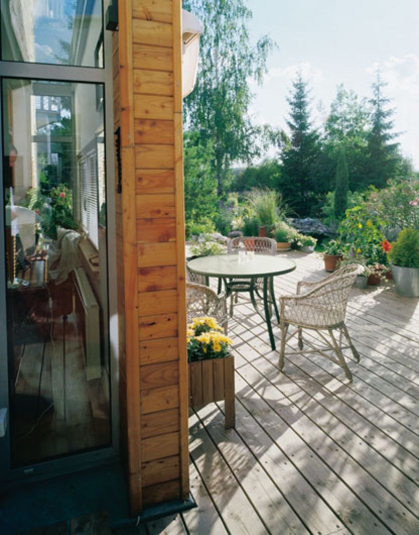 Drewnianego tarasu nie otaczają żadne barierki, jedynie rośliny w donicach. To daje poczucie przestrzeni.