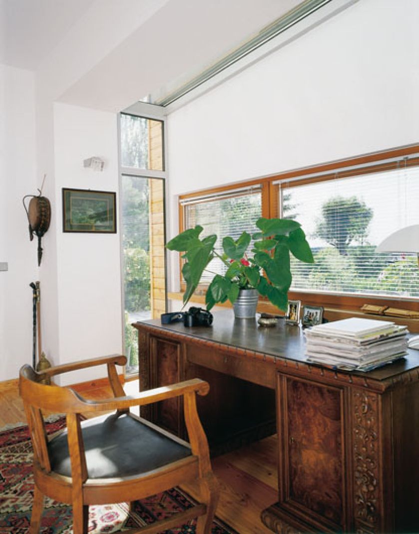 Dzięki przeszkleniu bocznych ścian gabinet pana domu został dosłownie wypchnięty do ogrodu.