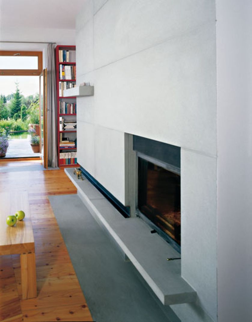 We wnętrzu, podobnie jak na elewacji, postawiono na kamień i drewno. Minimalistyczny kominek obudowano kamieniem.