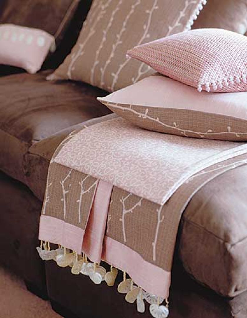 Narzuta (Melusine Shell - 171 zł/m2), różowa poduszka (Santini Shell - 228 zł/m2) i sofa (Suede Chocolate - 153