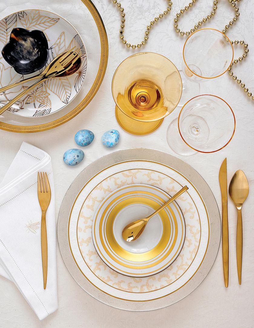 Stół z wiosenną dekoracją w kolorze złotym.