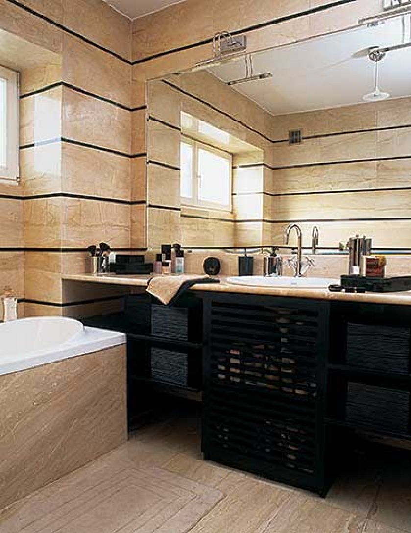 Stylistyczną konsekwencję widzimy też w łazience. Elegancki marmur podzielono poziomymi liniami, podobnie jak meble z