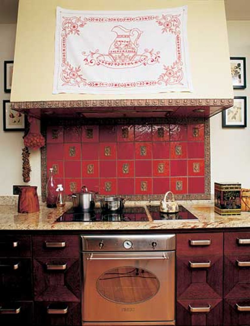 Kafle nad piecem Iwona wymyśliła sama. Czerwień ze złotymi wzorami symbolizuje ciepło domowego ogniska.