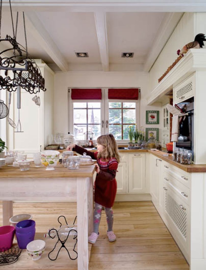 Pięcioletnia Ninka, z pomocą mamy, ozdabiają świeżo upieczone kruche ciasteczka kolorowym lukrem.