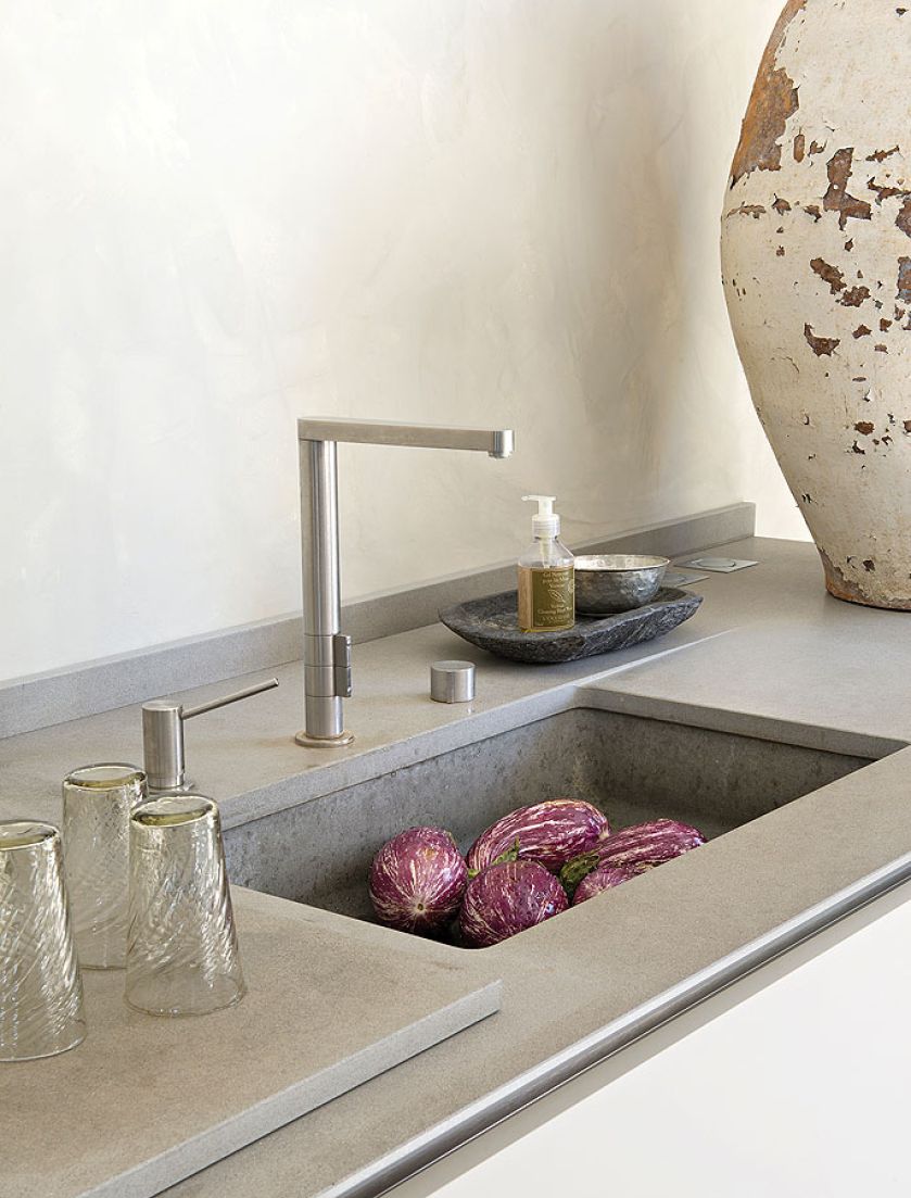 W kuchni stare przeplata się z nowym: nowoczesne, dizajnerskie baterie przy zlewozmywaku.