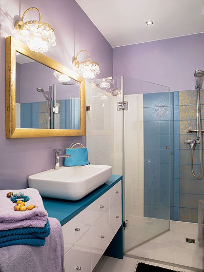 Barokowe kafelki, lustro w złotej ramie i kinkiety z kryształkami.