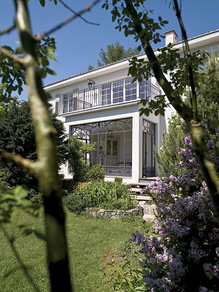 Dom jest zupełnie prosty, ale z prowansalskimi okiennicami, przeszklonym gankiem i wielkim drewnianym, białym tarasem.