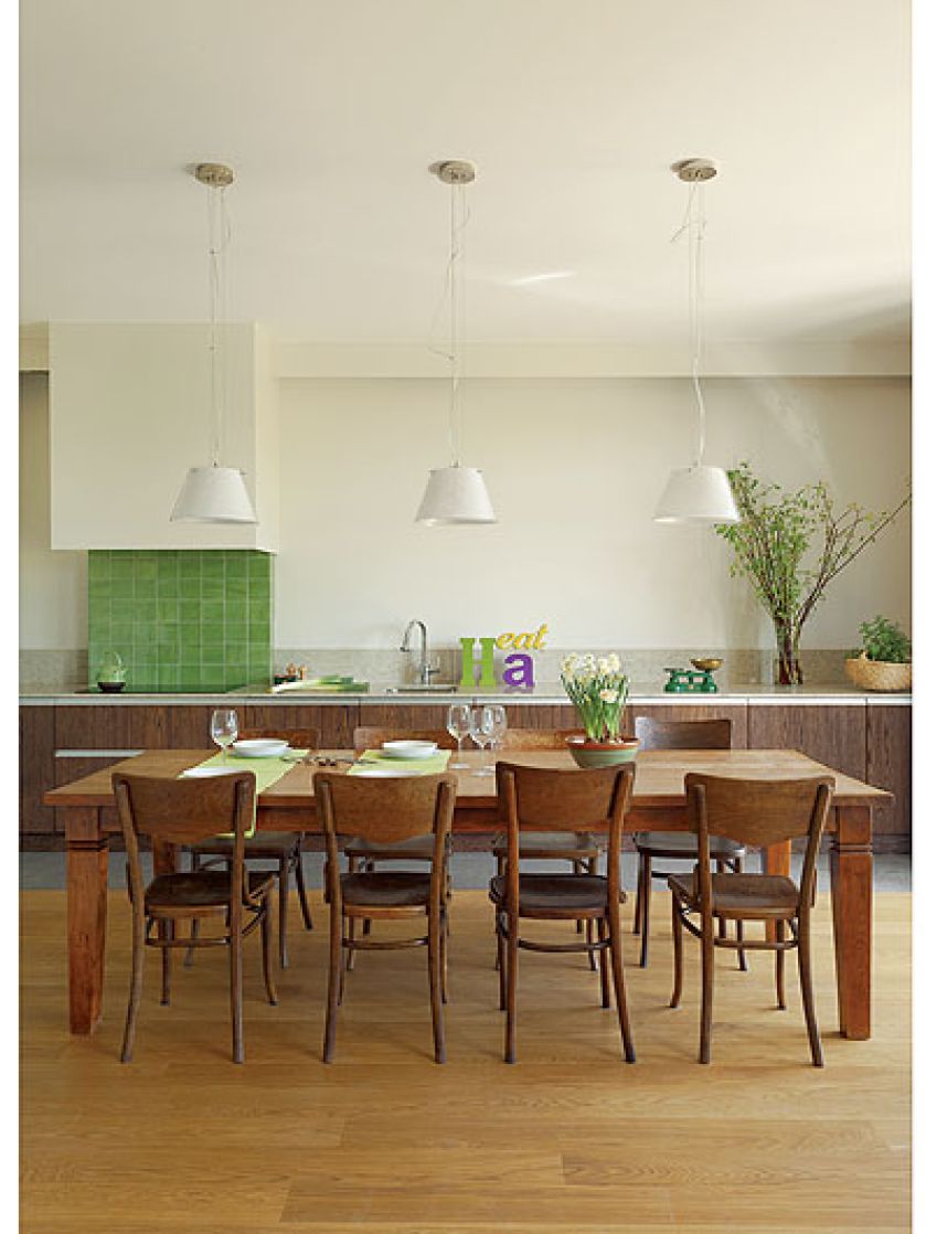 Duży rodzinny stół stoi między kuchnią a salonem.