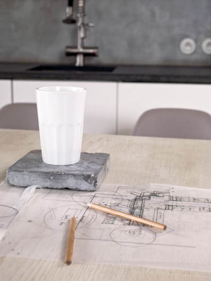 Kuchnia minimalistyczna, ale z ciekawymi krzesłami i drewnianym stołem na pięknych nogach.