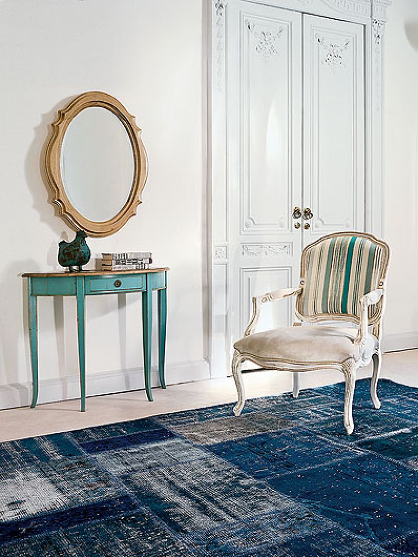 Konsola w kolorze polinezyjskiego turkusu i owalne lustro zrobione są z orzecha. TONIN CASA