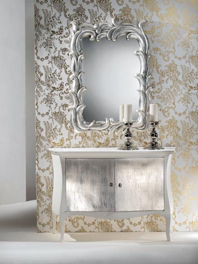 Lustro w rzeźbionej ramie i drzwiczki szafki wyłożono płatkami srebra. Projekt - Barbara i Luca Spini.