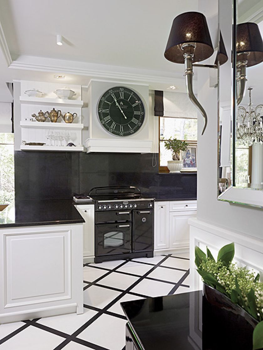 Mocne kontrasty: do białych szafek - czarny granitowy blat i czarny zegar.