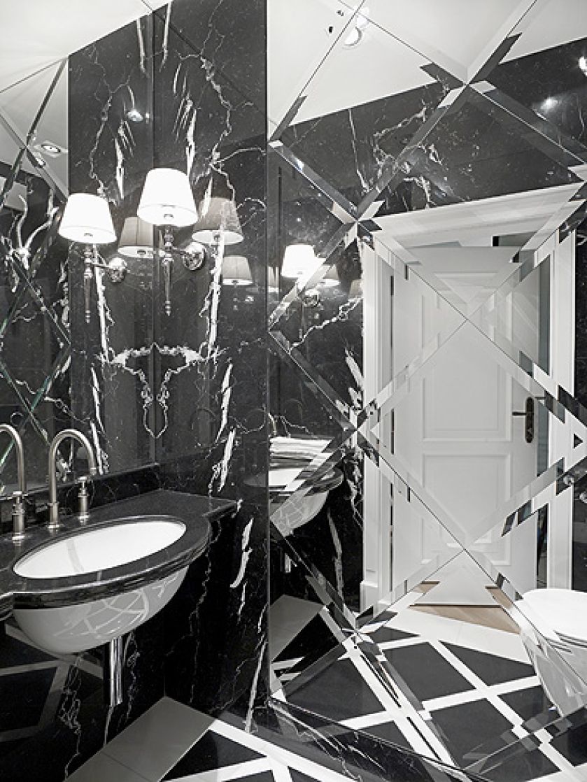 Żeby rozjaśnić łazienkę, jedną ze ścian wyłożono płytkami z fazowanych luster.