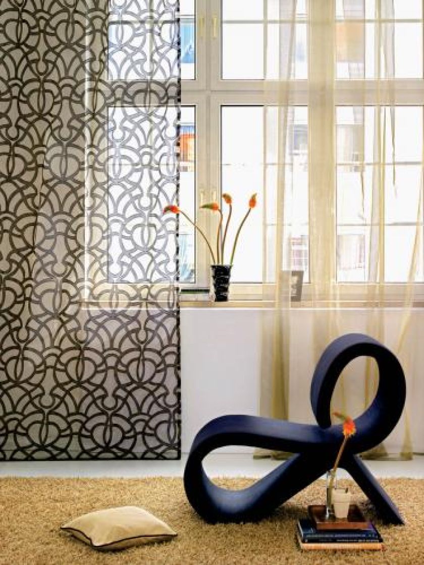 Przezroczystości na oknie. Firanka bez wzoru kosztuje 502 zł, z wzorem - 191 zł. Fotel z tkaniną Akira za 308 zł. DEKOMA