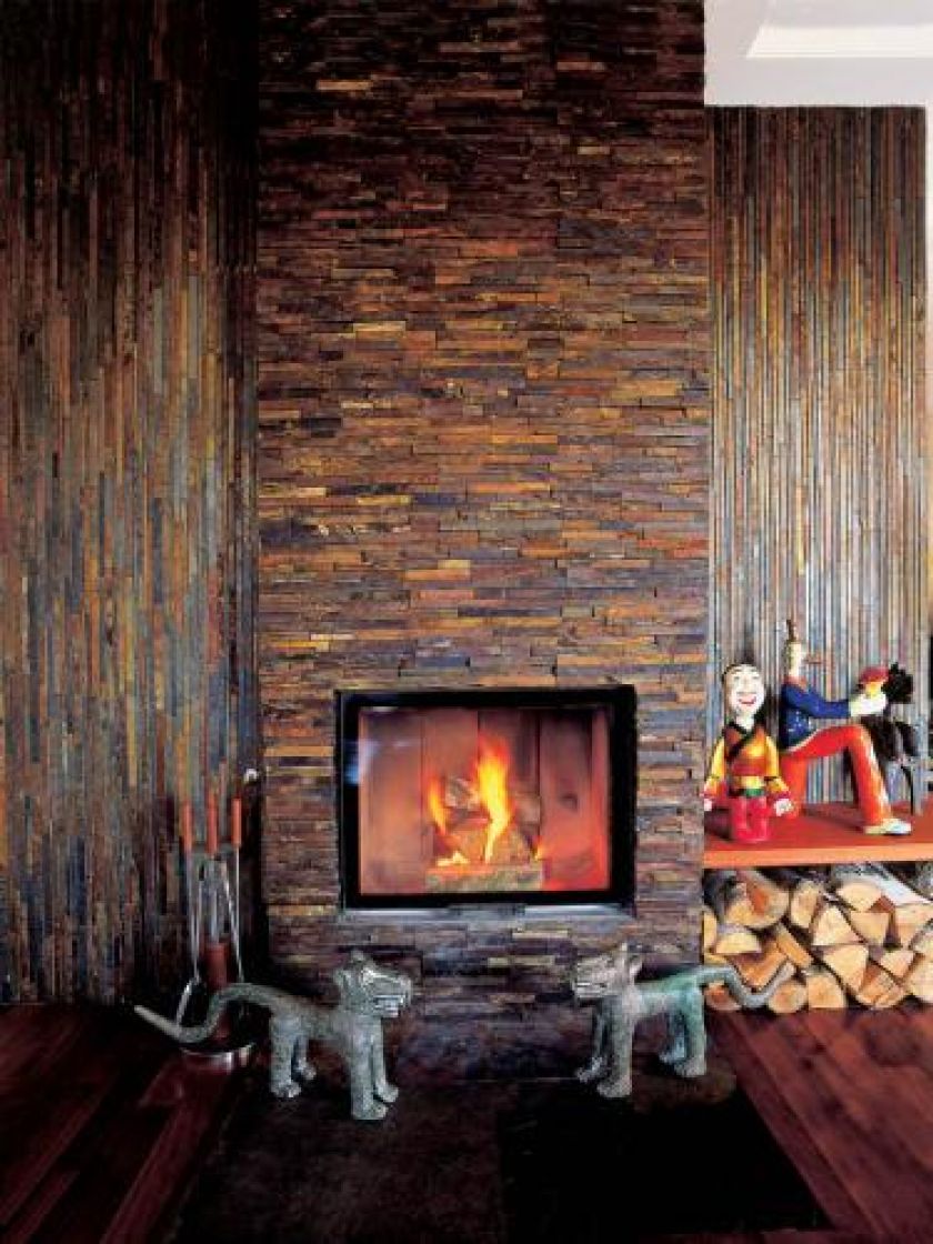 Przy wyłożonym kamieniem kominku stoją orientalne figurki - też, oczywiście, pamiątki z podróży.