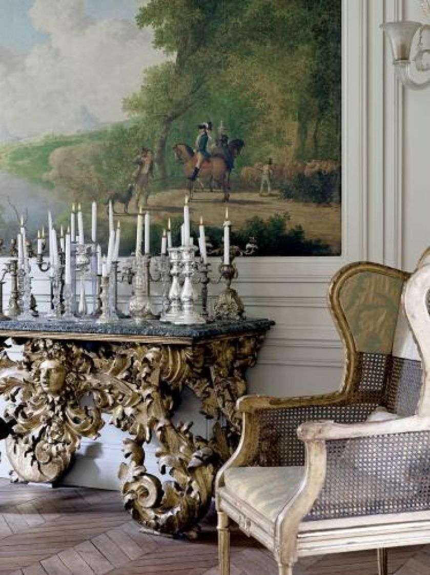 Na konsoli stoją różnorodne świeczniki.