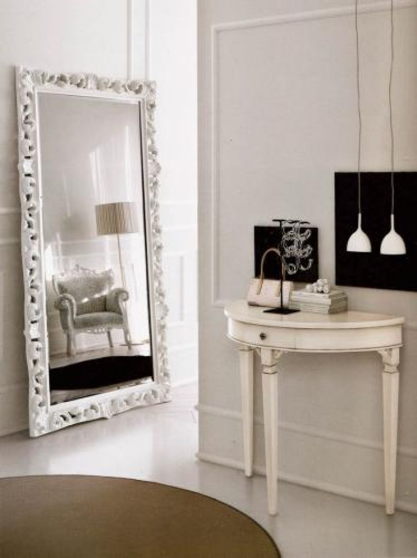 Zamiast tradycyjnie wieszać lustro nad konsolą, możemy oprzeć je o ścianę. Duża szklana tafla powiększy