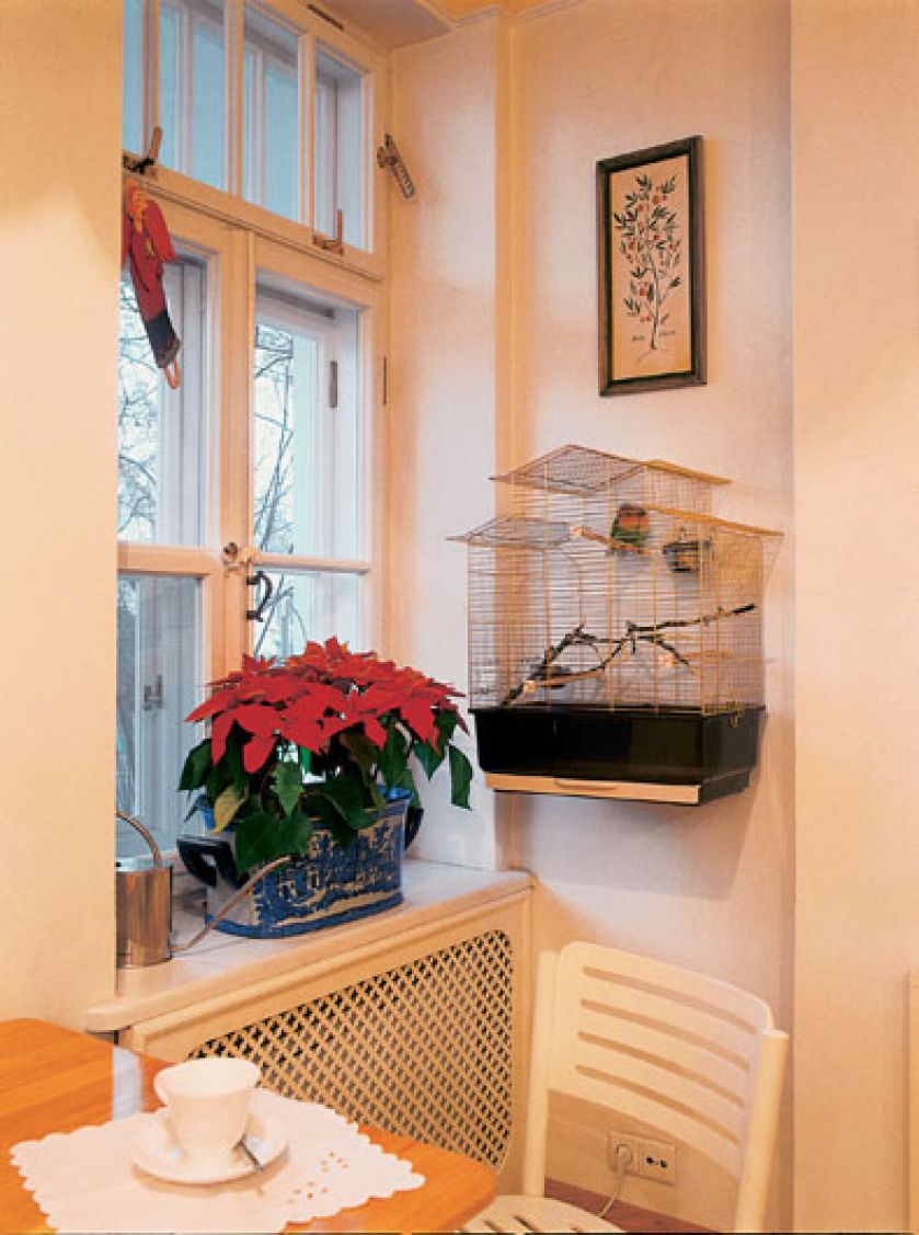 Architektoniczne detale przedwojennego domu podkreślają rustykalny chrakter wnętrza. Biale współczesne krzesła zupełnie przy