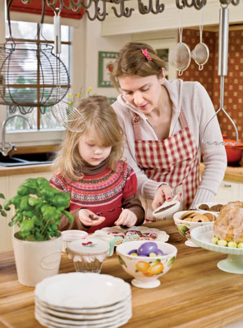 Przy kuchennej wyspie Ninka dekoruje pierniczki.