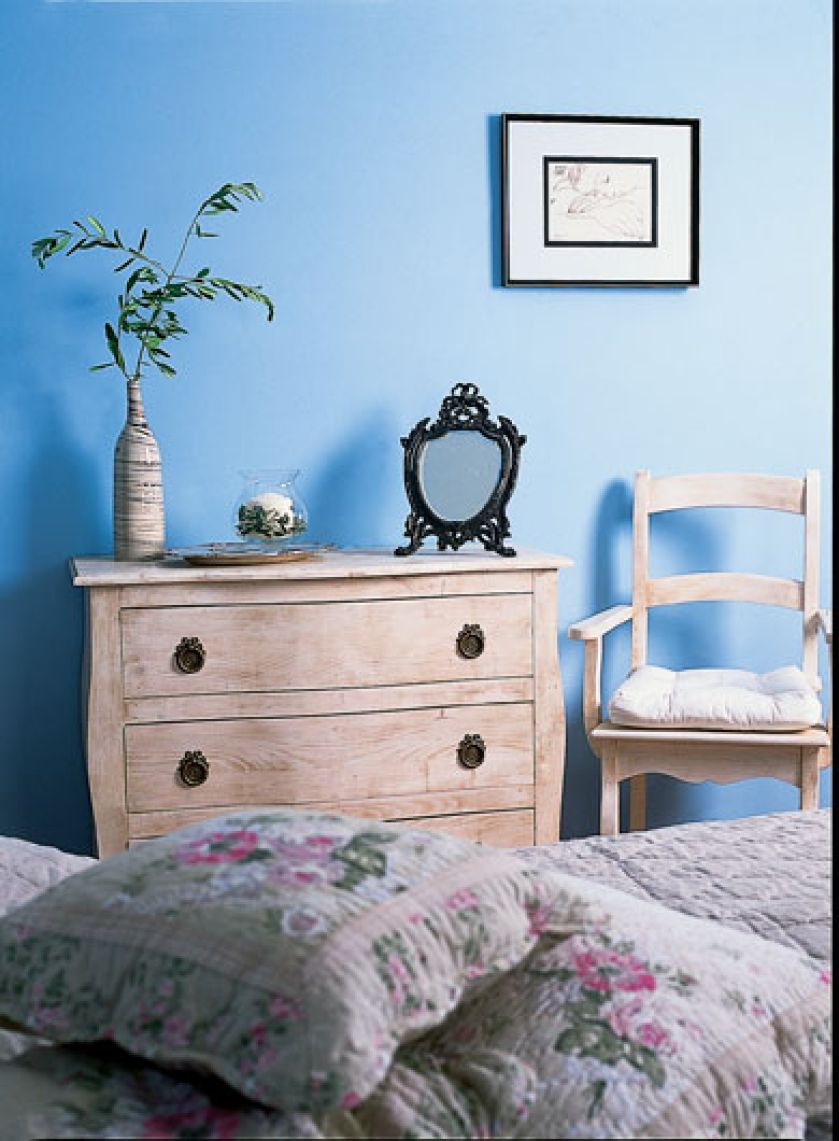 Kwintesencja prowansalskiego stylu - proste drewniane meble, pastelowe kolory i pikowane poduszki.