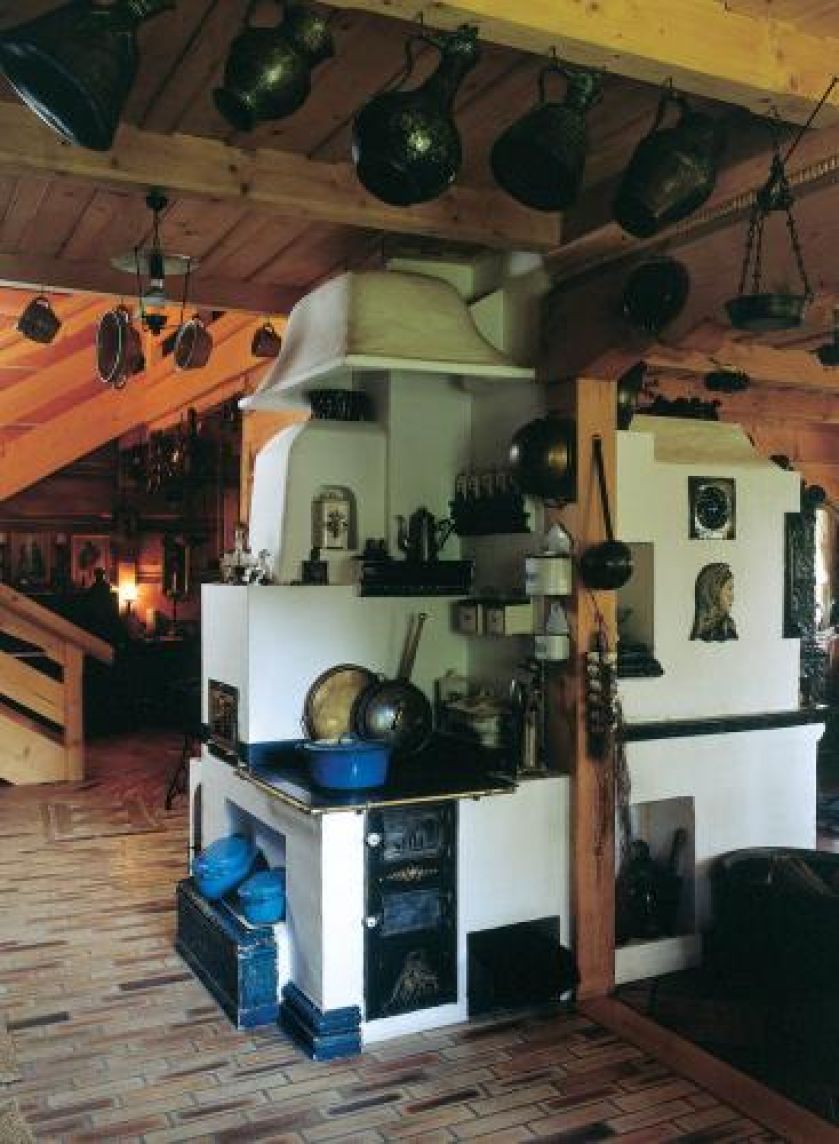 Kuchnie węglową otacza kolekcja starych naczyń.