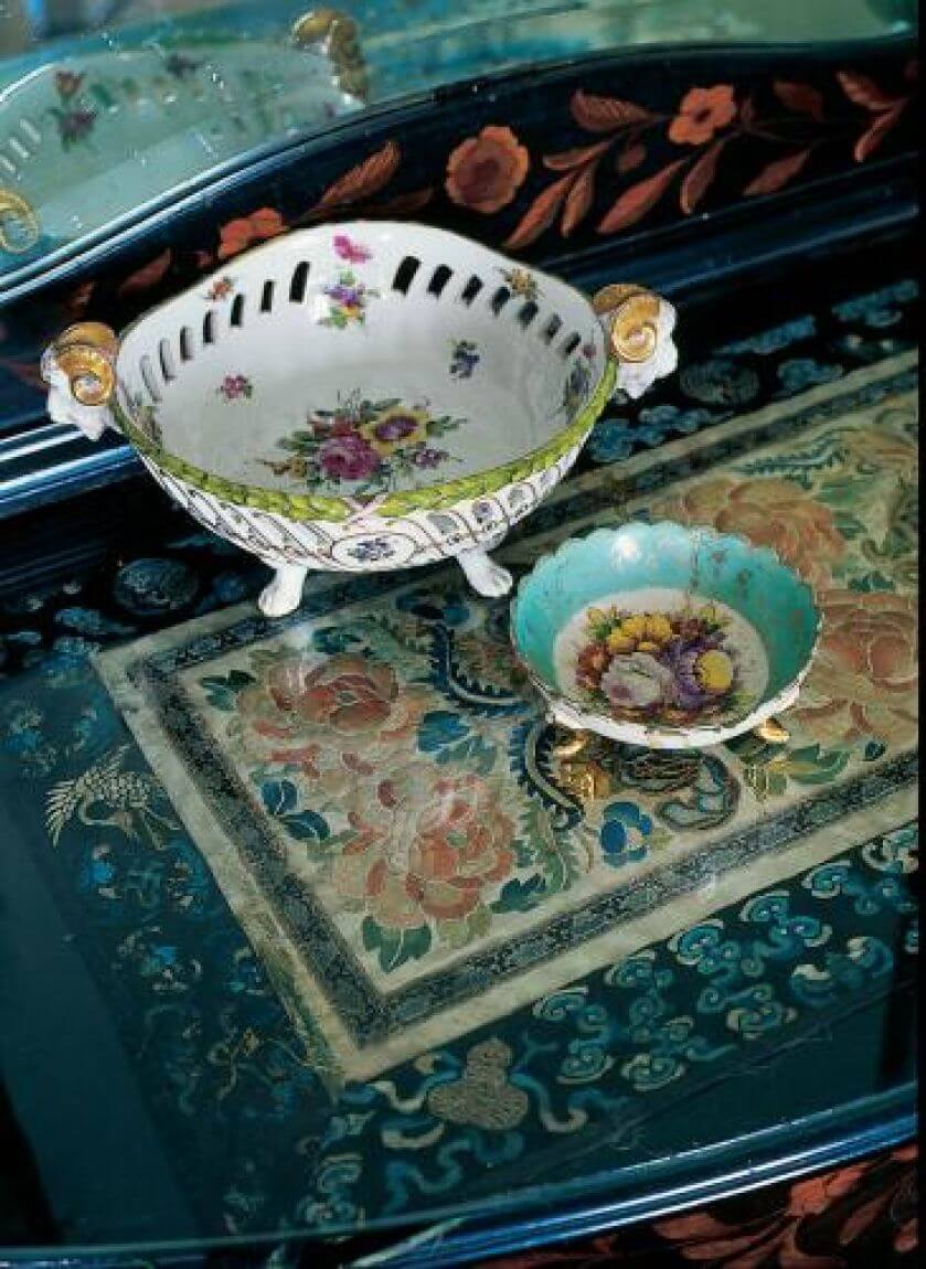 Na bogato zdobionej konsoli stoją pamiątki z Dalekiego Wschodu - misternie haftowana serweta i porcelanowe patery.