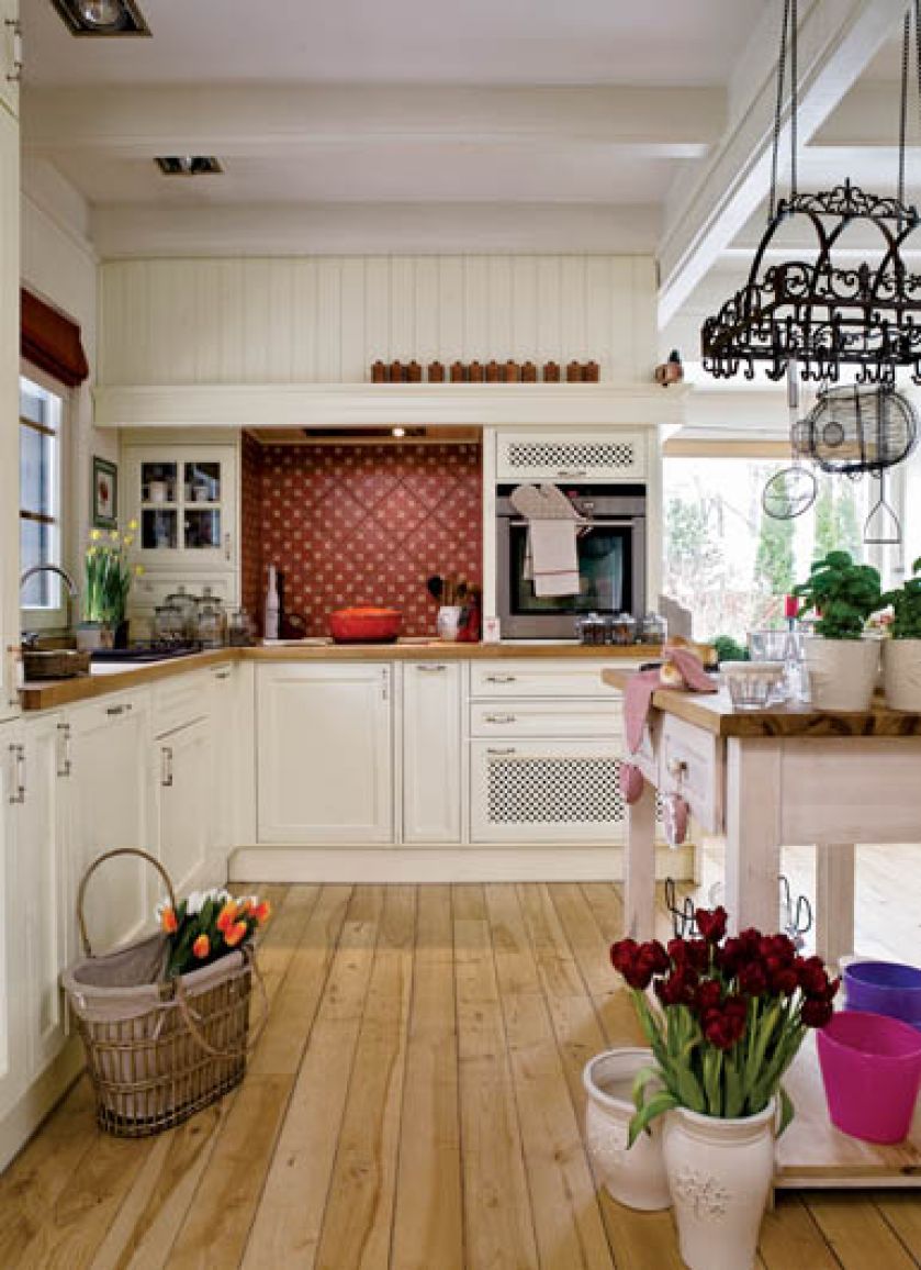 Atmosfera jak w Prowansji: drewno, jasne szafki kuchenne, naturalne światło.