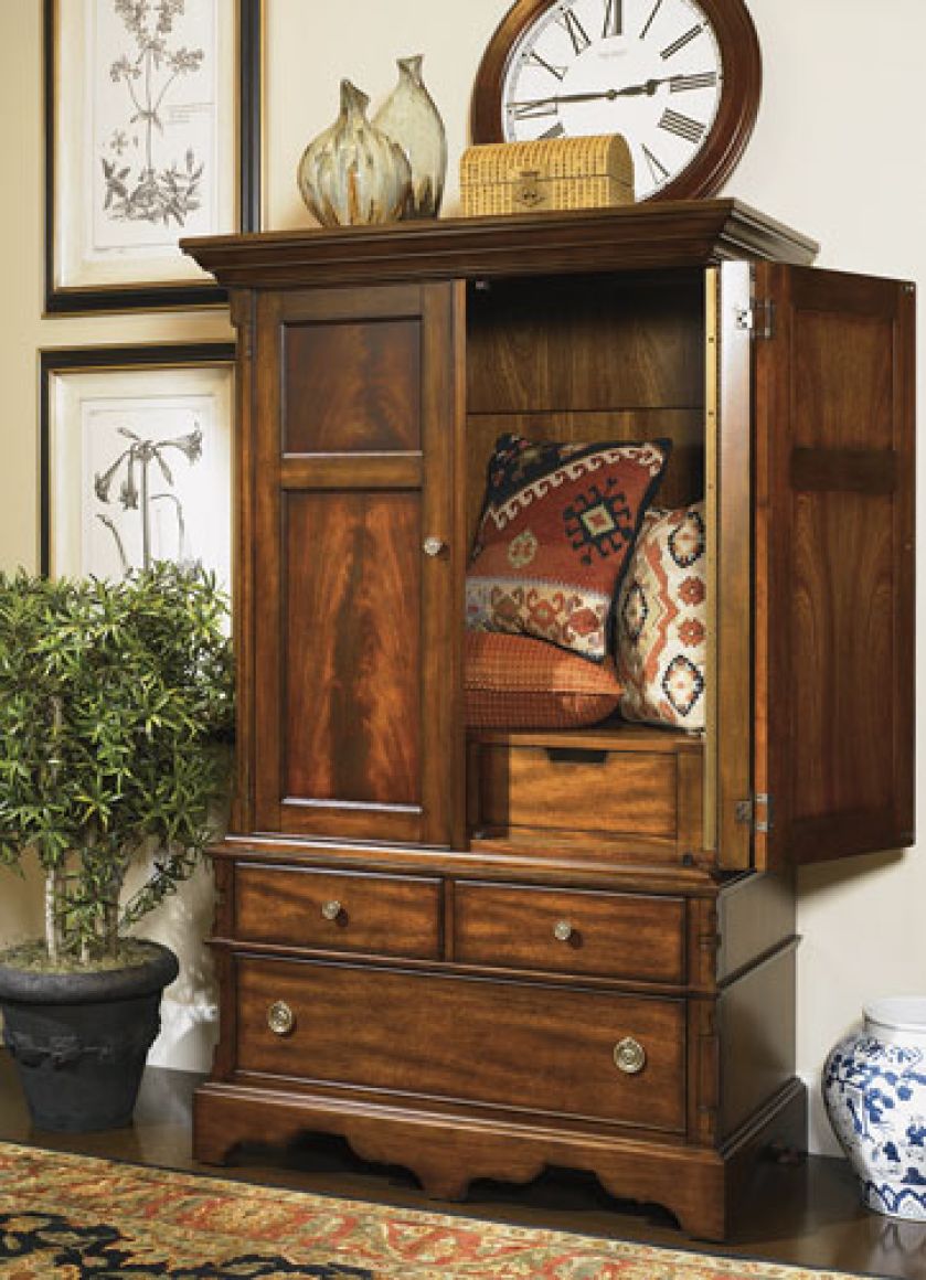 Klasyczne meble, ryciny, kolorowe poduchy i zegar w drewnianej ramie tworzą wnętrze stylowe, a przy