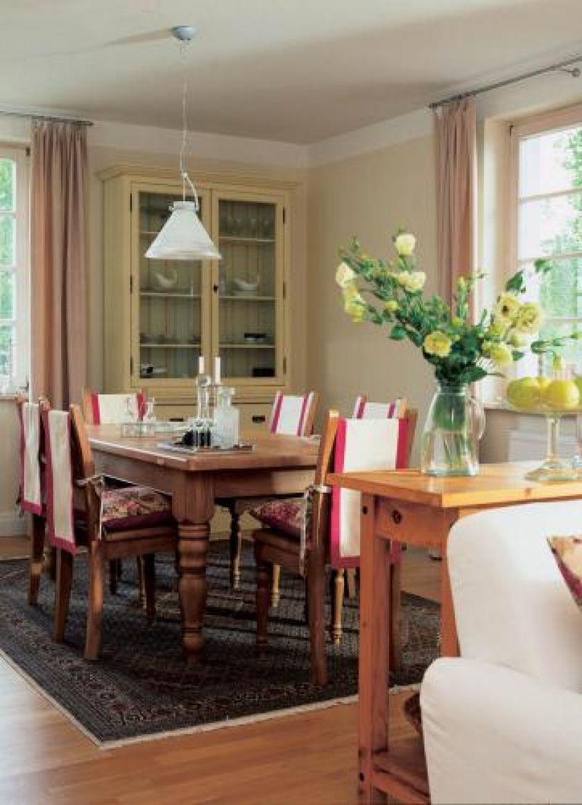 Krzesła zdobi tkanina i kolorowe poduszki.