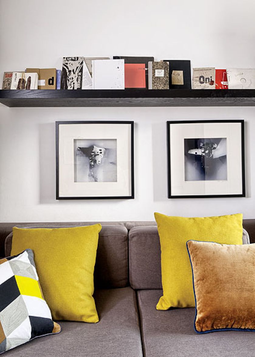 Fotografie Mariusza wiszą nad kanapą.