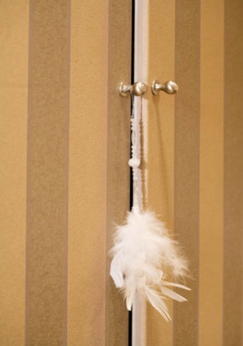 Na drzwiach do garderoby - ozdobny chwost z piórek.