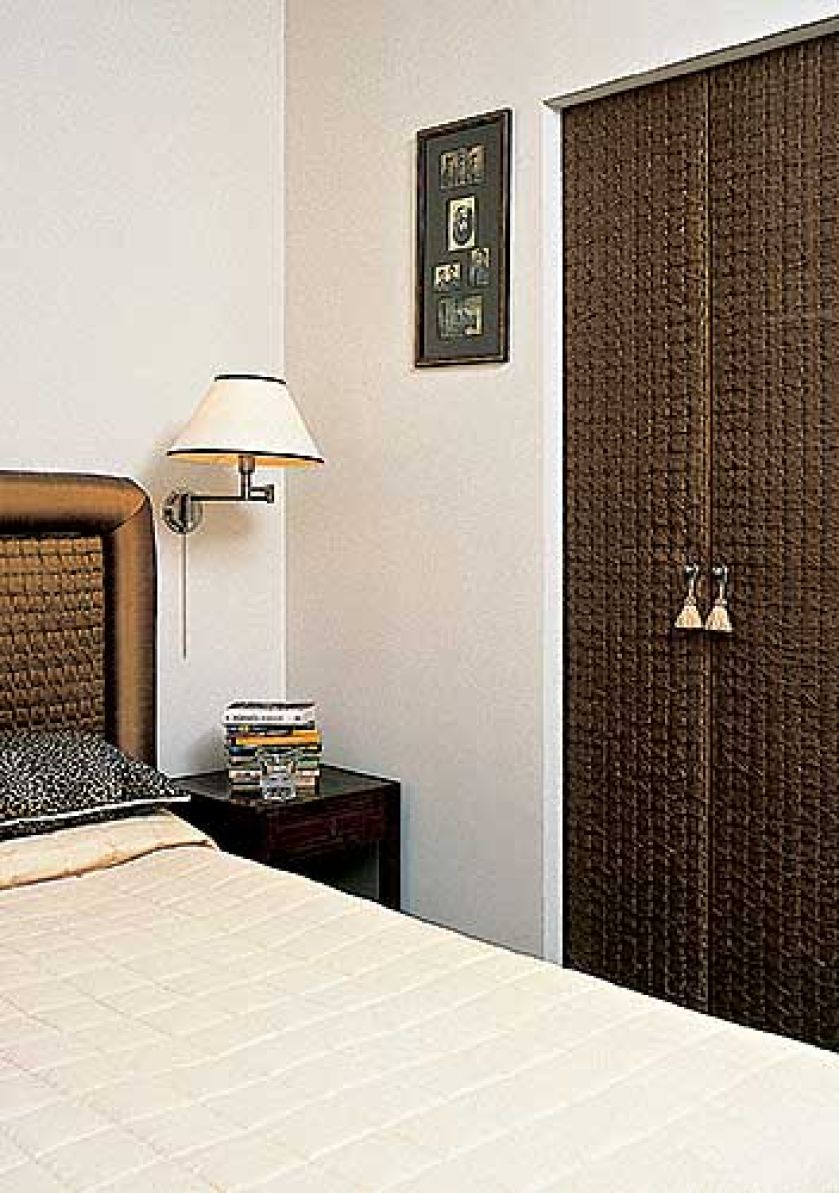 Wezgłowie łóżka wytapicerowano jedwabiem. W podobny sposób potraktowano drzwi obok, dodając im dla urody i