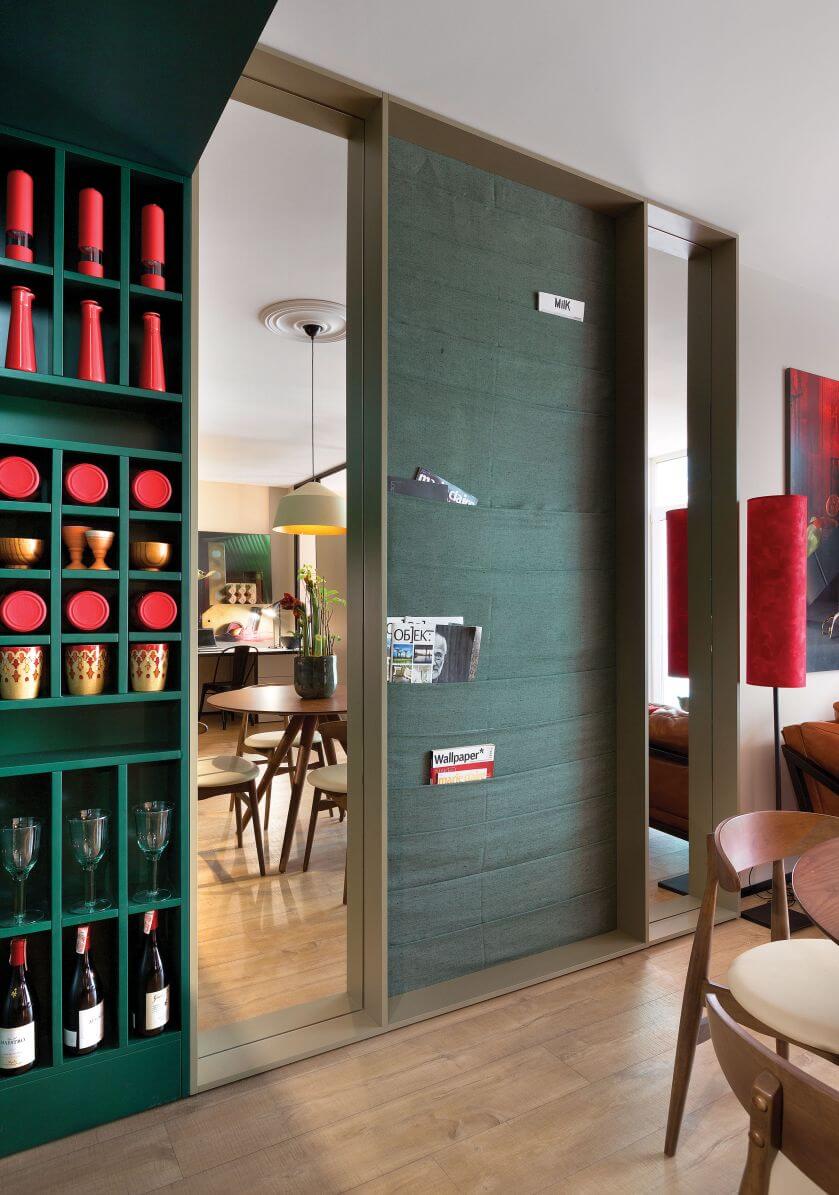 Pomiędzy lustrami znajduje się praktyczny schowek z przegródkami, zajmujący całą ścianę.