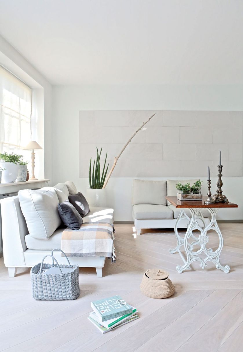 Skandynawskie kolory: rozbielona podłoga, ciepły piaskowiec na ścianie i lekko szare obicia kanap. Do tego