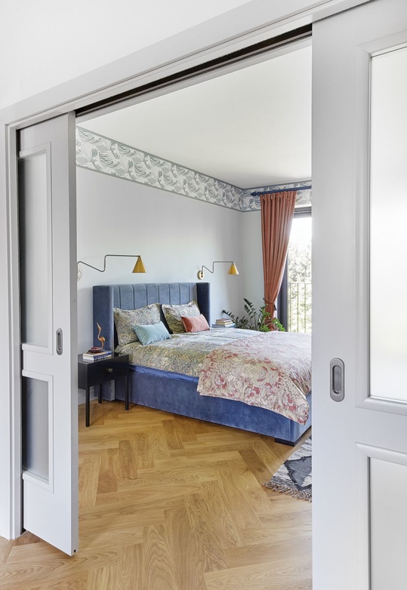 Przesuwne, stylowe drzwi między sypialnią a garderobą odtworzono na wzór oryginalnych. Gdy połączono je z