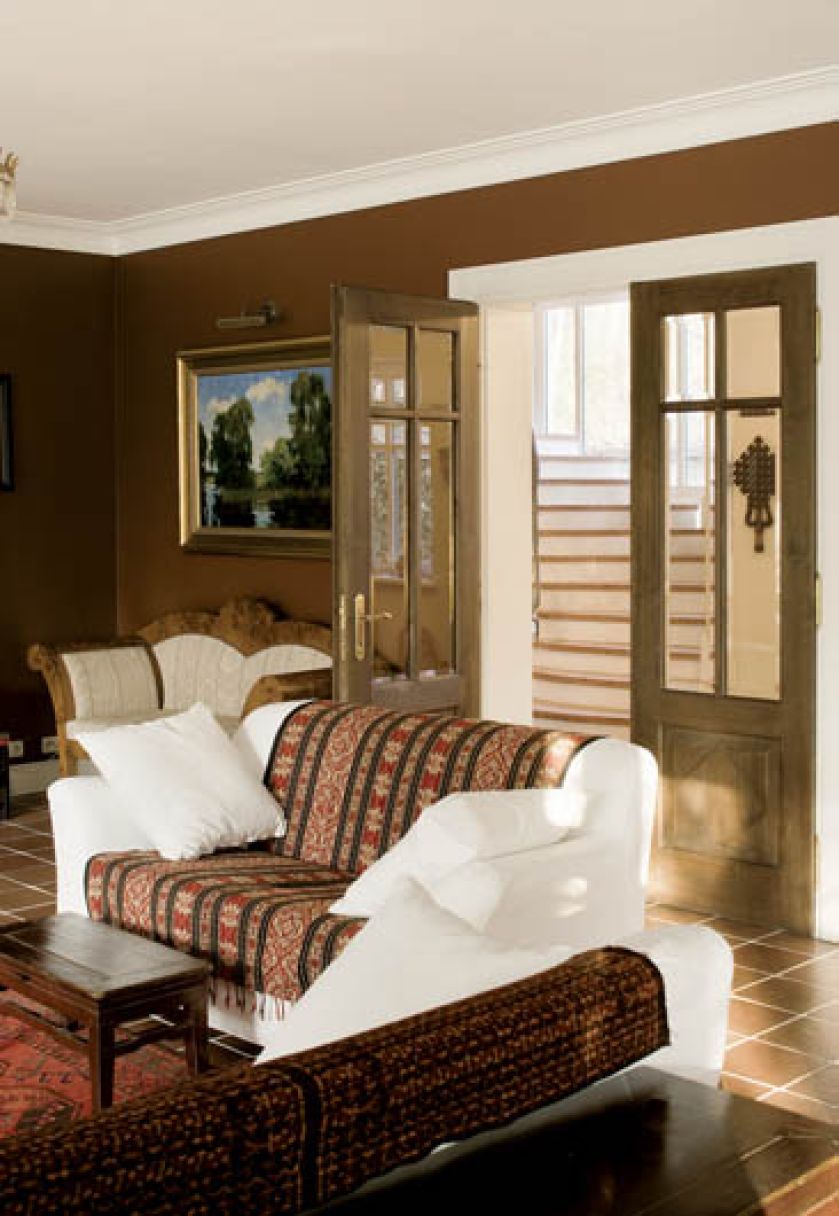 Ciemna podłoga i ściany oraz jasne kanapy nadają wnętrzu kontrastu.