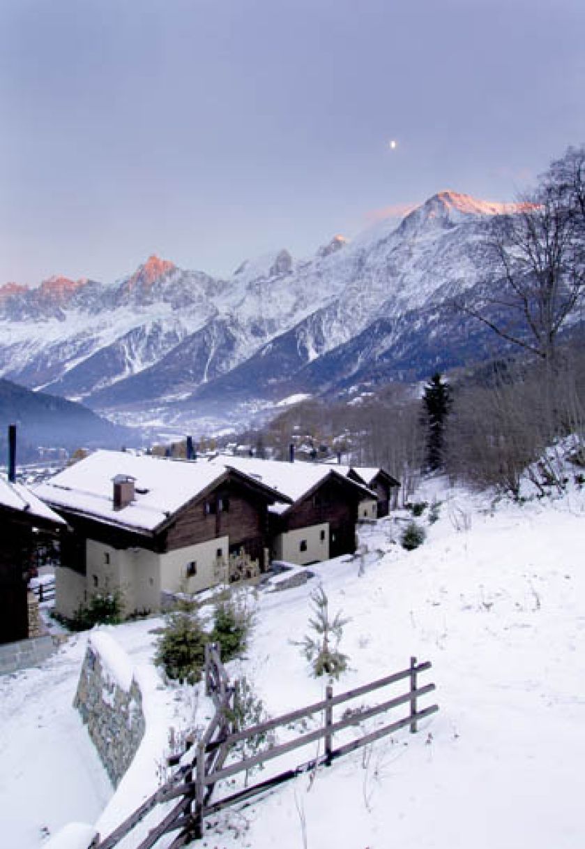 Widok na ośnieżone Alpy. Drewniany dom pod Mont Blanc