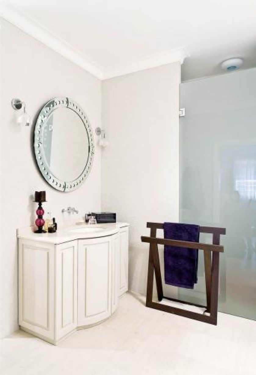 Nad umywalką okrągłe lustro. Apartament kosmopolityczny