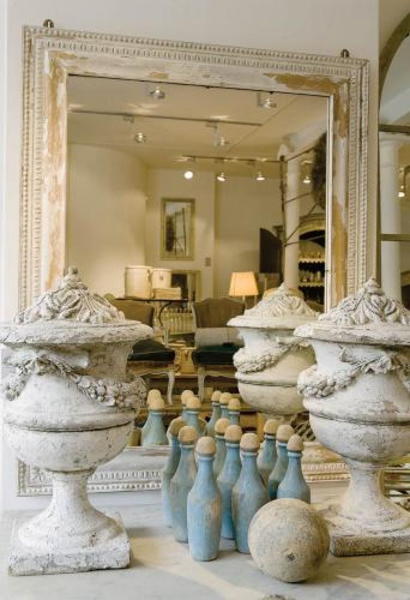 Przy lustrze stoją Kamienne dekoracje i ozdobne flakony.