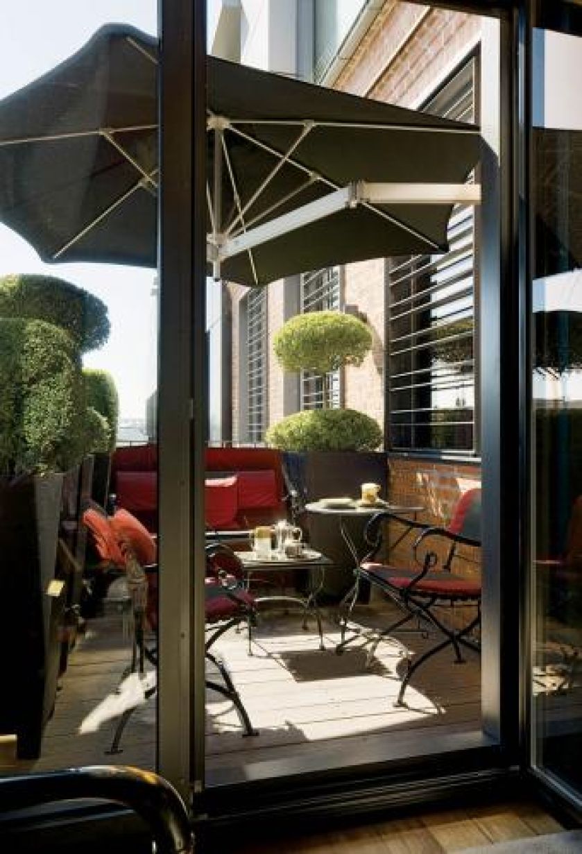 Na tarasie stoi komplet mebli. Apartament pełen smaków