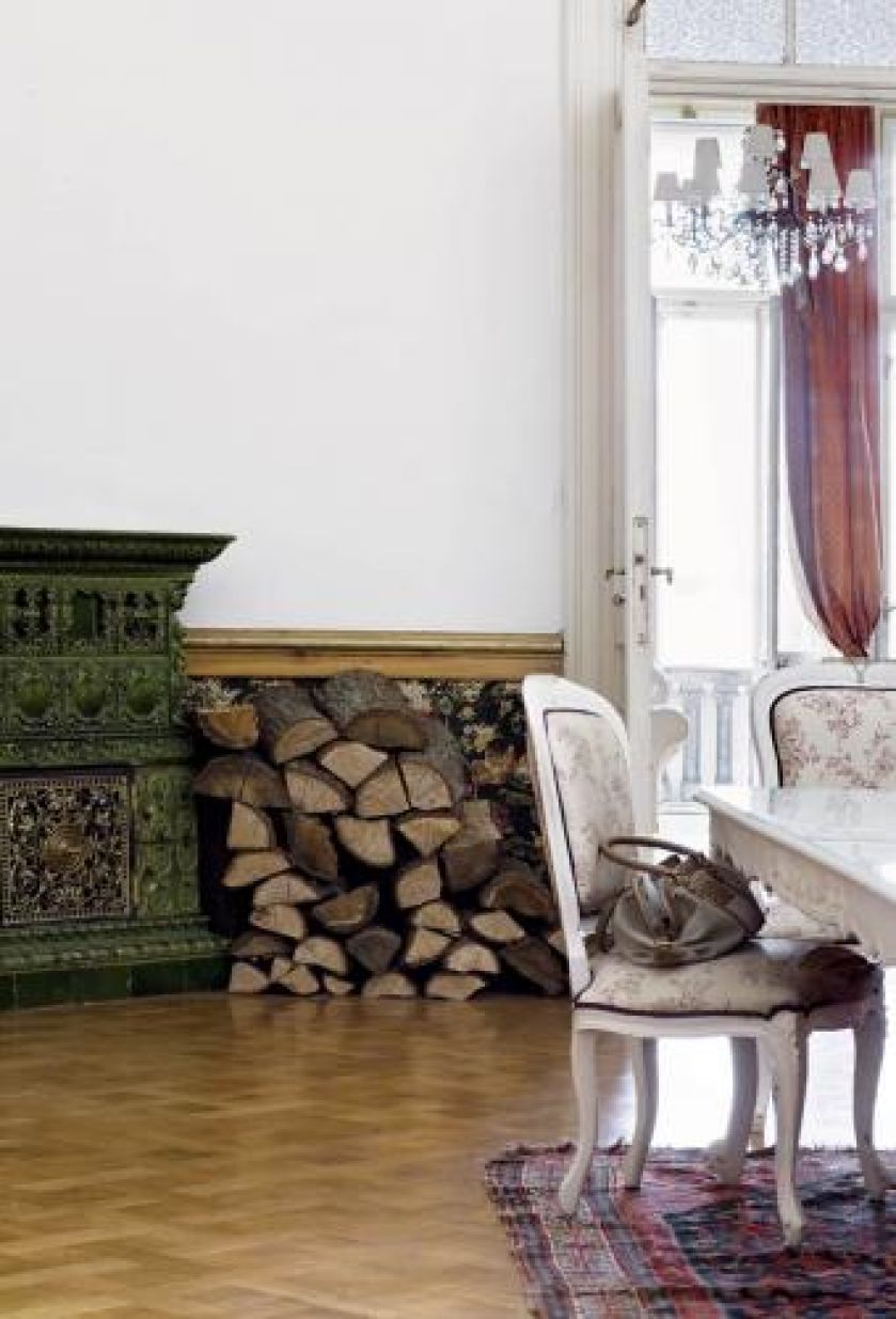 Obok pieca leży drewno przygotowane do spalenia.