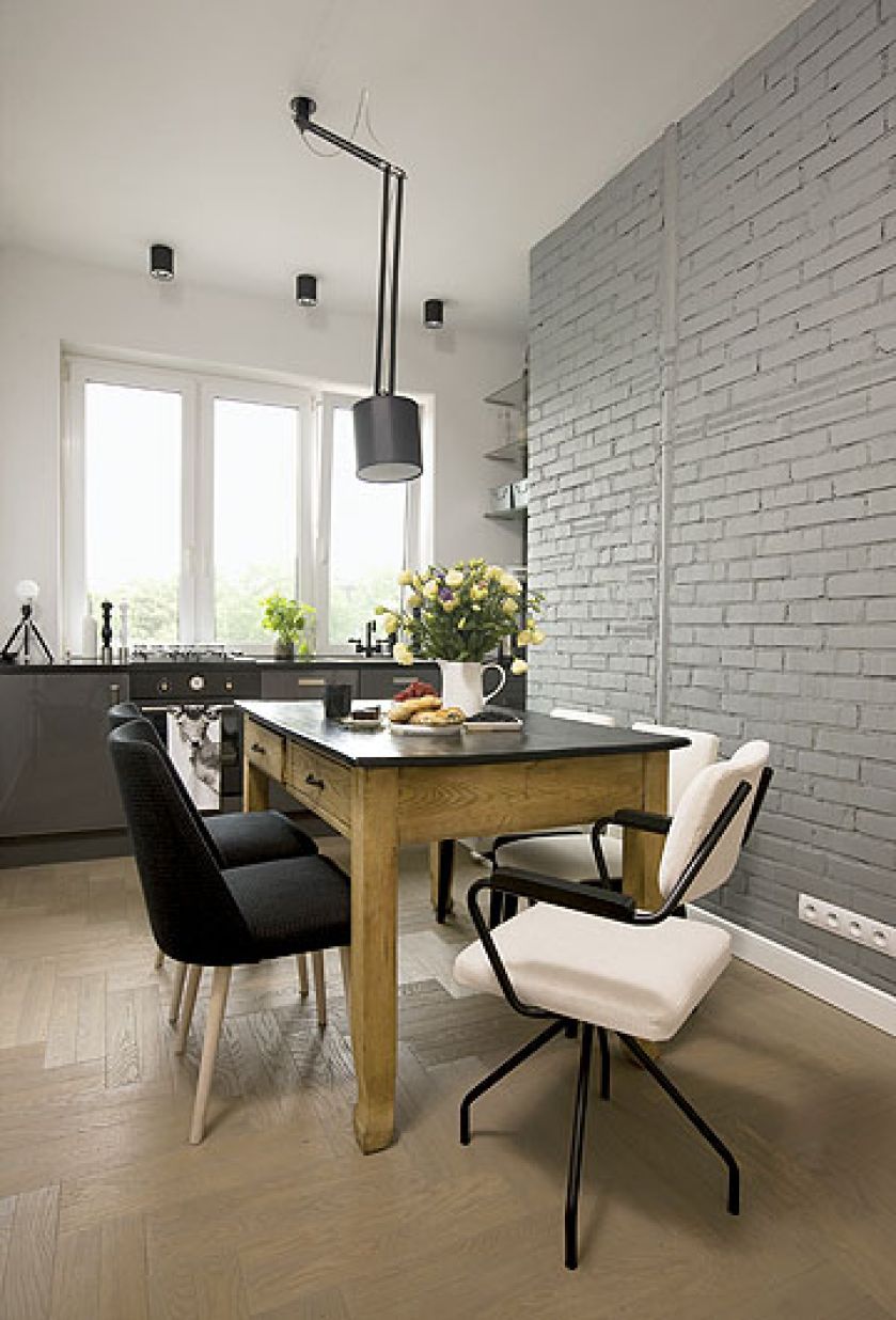 Przy kuchennym stole krzesła sa różne, ale wyśmienicie do siebie pasują.