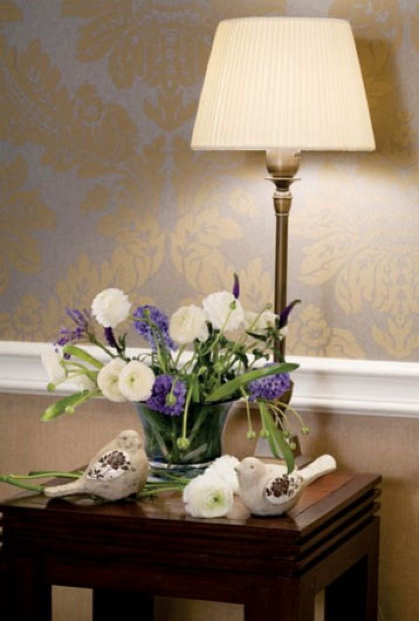 Na nocnym stoliku, obok lampki, rozgościły się ceramiczne ptaszki.