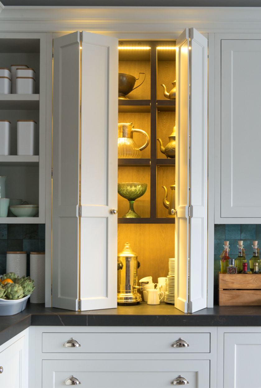 Dwie witryny stojące na blacie - jedna otwierana za pomocą skladanych drzwi.