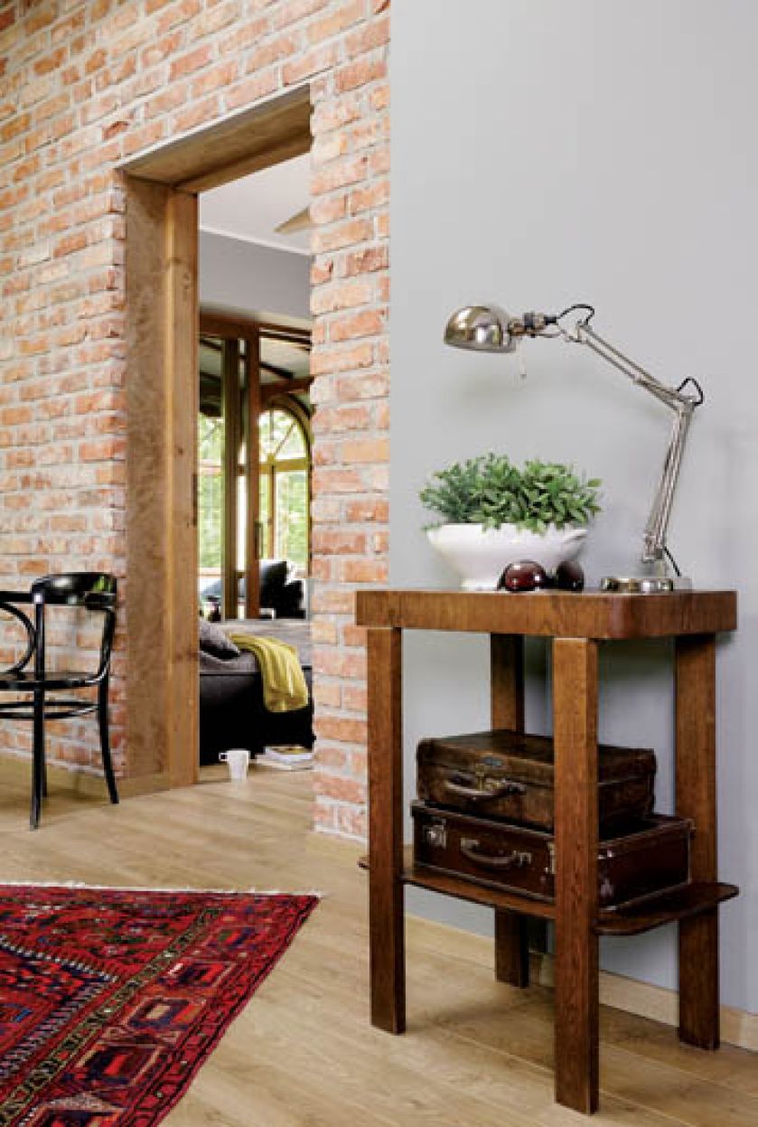 Artdekowski pomocnik, stare walizki i ceglana ściana doskonale wpisują się w klimat loftu.