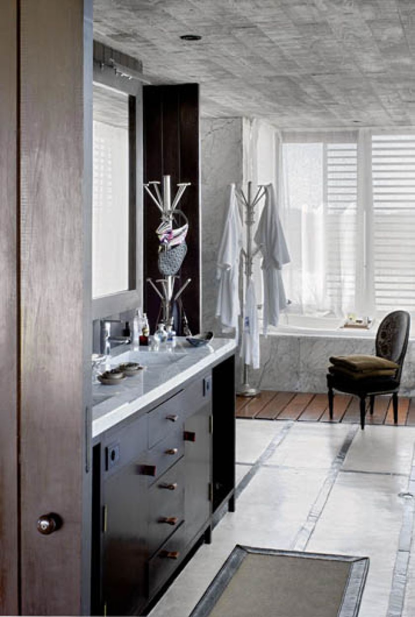 Ciekawa mieszanka materiałów pospolitych ze szlachetnymi. Surowe dechy w sąsiedztwie chłodnego marmuru stają się bardziej