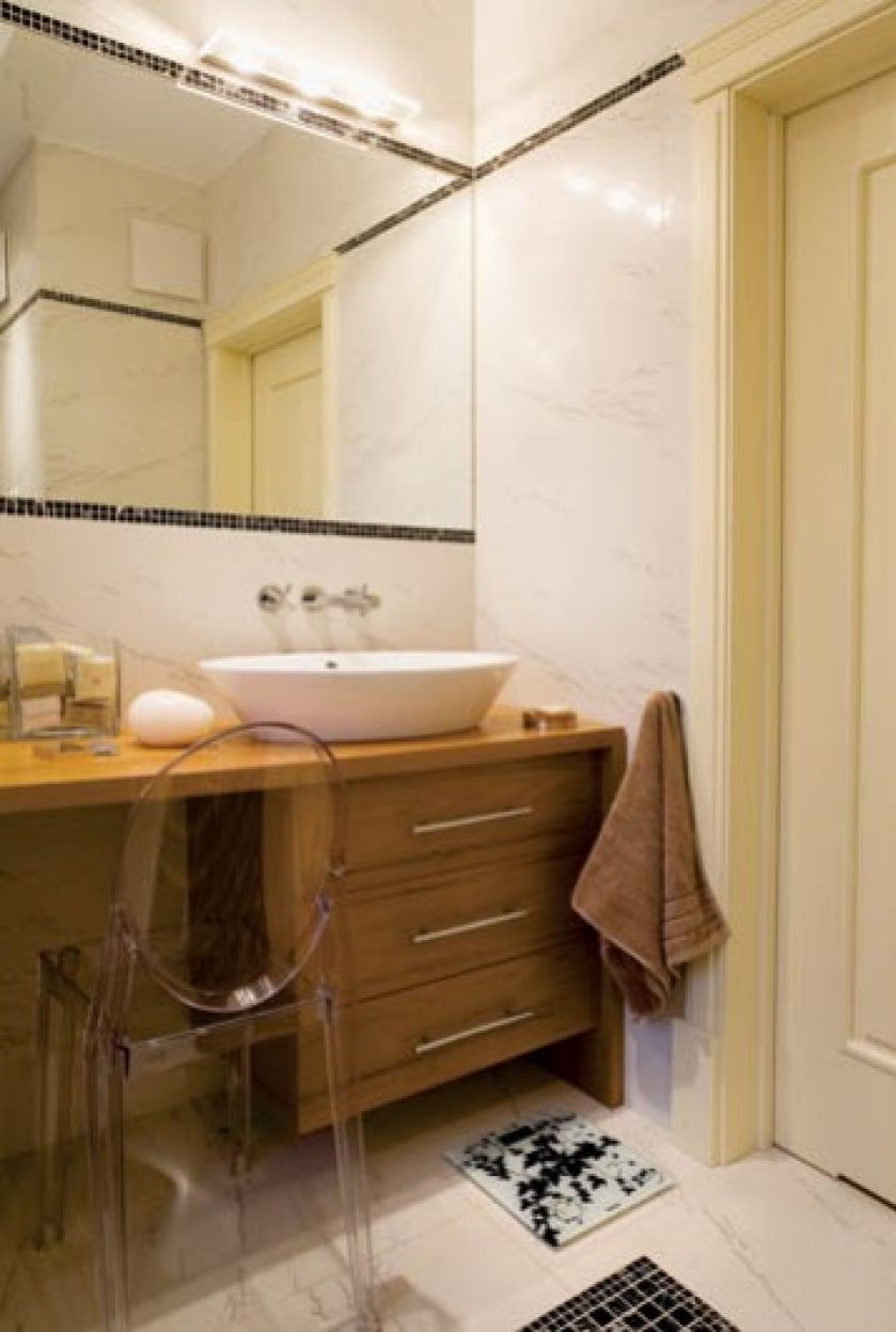 Ciepły kolor drewna kontrastuje z chłodną bielą marmuru na ścianach i podłodze.