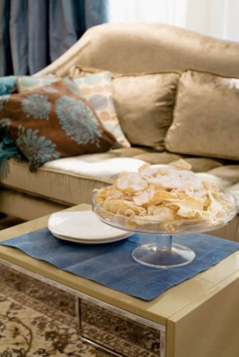 Beżowa kanapa przełamuje dominujące w tym salonie błękity.